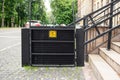 Electric platform lift at building staircase for disabled people with wheelchair sign plate on old city street. Elevator