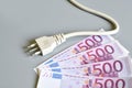Electric plug with euro money banknotes over grey background. Concept for the increase of electricity cost. Expensive energy bill Royalty Free Stock Photo