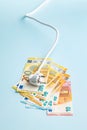 Electric plug and euro money on blue background. Concept of increasing electric prices Royalty Free Stock Photo