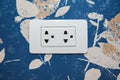 Electric plug outlet isolated on flower wallpaper.