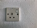 Electric plug socket on white wall. Selective focus Royalty Free Stock Photo