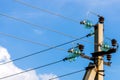 Electric pole against the blue clear sky. Three-phase power line to turn Royalty Free Stock Photo