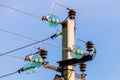 Electric pole against the blue clear sky. Three-phase power line to turn Royalty Free Stock Photo