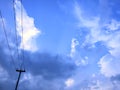 Electric pole, blue sky and white clouds. Royalty Free Stock Photo