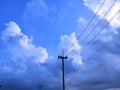 Electric pole, blue sky and white clouds. Royalty Free Stock Photo