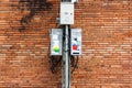 Electric pole with dirty electrical control box and cable, brick Royalty Free Stock Photo