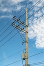 Electric pole and electric transformer with a clear blue sky background in portrait format