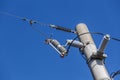 Electric pole with high voltage wires and isolators on blue sky with copy space. Royalty Free Stock Photo