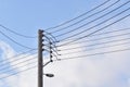 Electric pole with street lamp and wires against blue sky background. Royalty Free Stock Photo