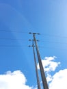 An electric pole, a very clear blue sky and white clouds Royalty Free Stock Photo
