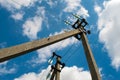 Electric pole with wires against a blue sky with clouds Royalty Free Stock Photo