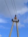 electric pole with wires against the blue sky and white clouds Royalty Free Stock Photo