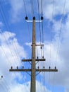 electric pole with wires against the blue sky and white clouds Royalty Free Stock Photo