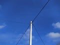 electric pole with wires against the blue sky and white clouds Royalty Free Stock Photo