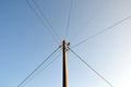 Electric pole with wires against a clear blue sky. Royalty Free Stock Photo