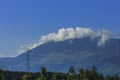 Electric poles and cabs, with a mountain backdrop, under a blue sky, Aceh