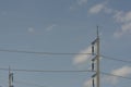 Electric poles and high voltage transmission lines on blue sky with clouds Royalty Free Stock Photo