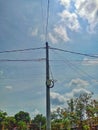 Electric poles in settlements with lots of wires under which there are rambutan trees