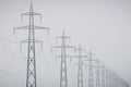 Electric power distribution network, on greyish sky Royalty Free Stock Photo