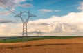 Electric power lines and agricultural fields. High voltage electric transmission towers and wheat field Royalty Free Stock Photo