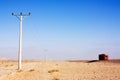 Electric power poles in desert of Jordan, high voltage powerlines, red truck on morning road. Royalty Free Stock Photo