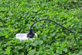 Electric power receptacle on a green grass background Royalty Free Stock Photo