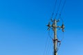 electric power sky lines and connections on a wooden post. wooden electricity post against blue sky. Electric power lines and Royalty Free Stock Photo