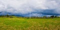 Electric power transmission pole in the mountains with cables along a wooden rail fence leading to the village. Panoramic