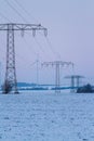 Electric power lines with wind turbines in winter landscape, germany, thuringia