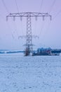 view of electric power lines with wind turbines in winter landscape, germany, thuringia