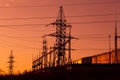 Electric powerlines on electric substation and distribution power. High voltage power lines, pylons against orange sky