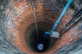 Electric pump in the groundwater well with water in the bottom