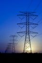 Electric Pylons against blue sky with sun Royalty Free Stock Photo