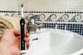 Electric Rechargeable Toothbrush with a Black Handle and five Toothbrush Heads.Light blue background