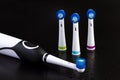 Electric rechargeable toothbrush with three toothbrush heads on black