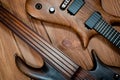 Electric rhythm guitar and five-string bass photographed on a wooden surface