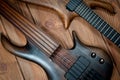 Electric rhythm guitar and five-string bass photographed on a wooden surface