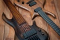 Electric rhythm guitar and five-string bass photographed on a wooden surface