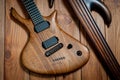 Electric rhythm guitar and five-string bass photographed on a wooden surface