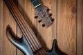 Electric rhythm guitar and five-string bass photographed on a wooden surface