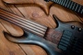 Electric rhythm guitar and five-string bass photographed on a wooden surface