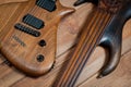 Electric rhythm guitar and five-string bass photographed on a wooden surface