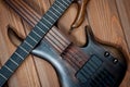 Electric rhythm guitar and five-string bass photographed on a wooden surface