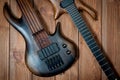 Electric rhythm guitar and five-string bass photographed on a wooden surface