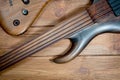 Electric rhythm guitar and five-string bass photographed on a wooden surface