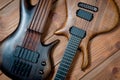Electric rhythm guitar and five-string bass photographed on a wooden surface