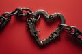 Electric Romance: A heart-shaped metal chain held together by jumper cable clamps against a striking red background Royalty Free Stock Photo