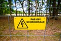 Electric safety fence with yellow danger sign written in Dutch Royalty Free Stock Photo