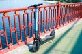 Electric scooter on the pedestrian bridge. Electric scooter rental for walking. Close-up photo. The river is in the background