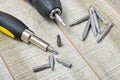 Electric screwdriver, self-tapping screws, screwdriver bits, tool box on a wooden background